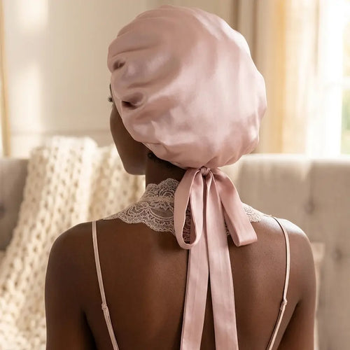 Bonnet de nuit rose poudré en soie de mûrier vu de dos, noué avec un ruban