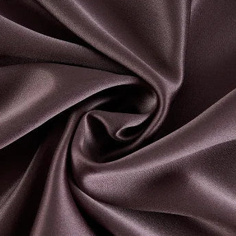 Gros plan sur un tissu en soie de mûrier de couleur marron chocolat aux reflets satinés et drapés fluides.