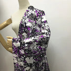 Étoffe en soie de mûrier blanche avec imprimé floral abstrait dans les tons violet électrique et noir sur mannequin.