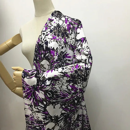 Étoffe en soie de mûrier blanche avec imprimé floral abstrait dans les tons violet électrique et noir sur mannequin.