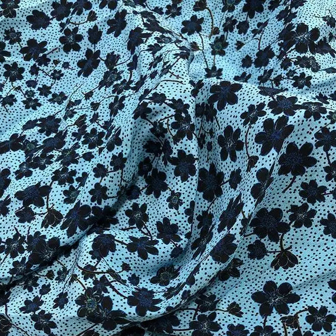 Tissu en soie de mûrier naturelle bleu ciel avec motifs de petites fleurs noires et plumetis.