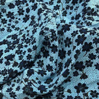 Tissu en soie de mûrier naturelle bleu ciel avec motifs de petites fleurs noires et plumetis.