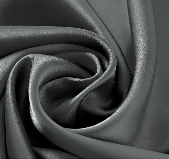 Gros plan sur un tissu en soie de mûrier gris anthracite avec reflets argentés, parfait pour des créations de mode contemporaines.