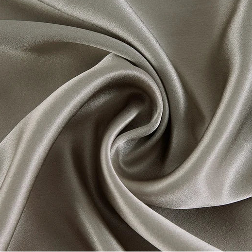 Étoffe en soie de mûrier gris, texture fluide et brillante pour confection de luxe.