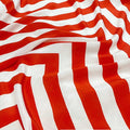 Tissu en soie de mûrier à motifs chevrons géométriques rouge vif et blanc, textile graphique et satiné vendu à la coupe pour création de mode.